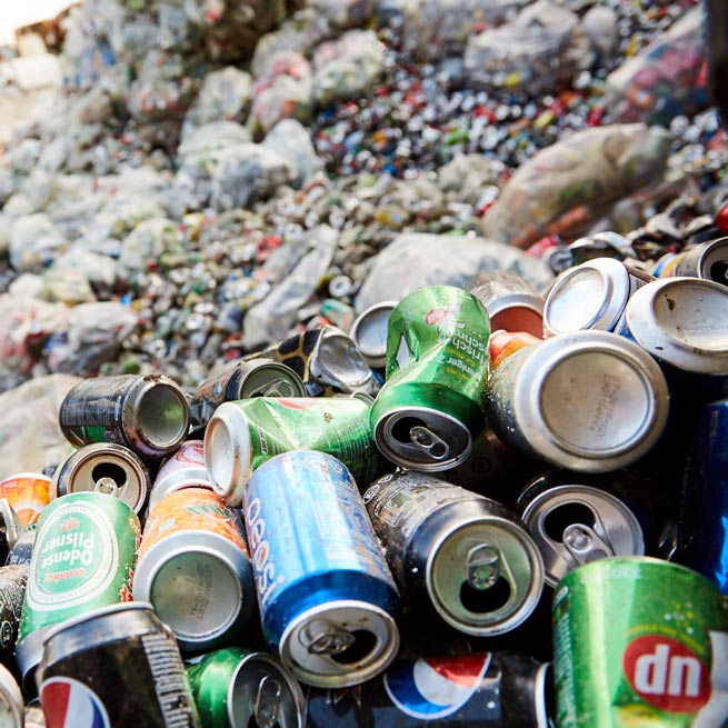 sammenkrøllede dåser af aluminium og jern fra øl, sodavand og cider i mange farver sendt til genanvendelse