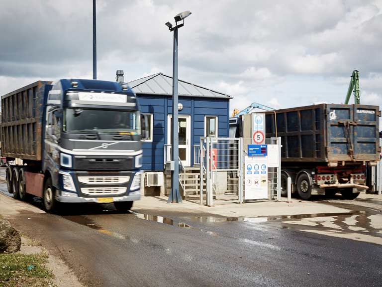 Volvo lastbiler kører ind og ud af brovægt med skrot ved HJHansen Recycling