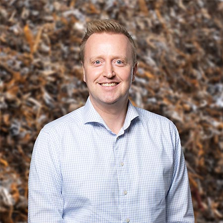 Martin-Friis-HJHansen-Recycling Portrætbillede af Martin Friis Aaquist der er produktchef for jern hos HJHansen. Han er iført lyseblå- og hvidternet skjorte.